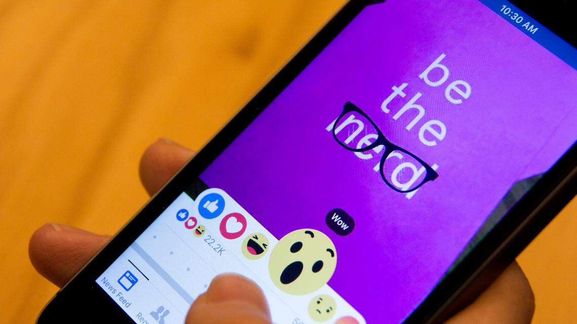 In this 2016 photo taken in New York, Julie Zhuo, product design director at Facebook, demonstrates new emoji-like stickers customers will be able to press in addition to the like button. (AP Photo/Mary Altaffer)