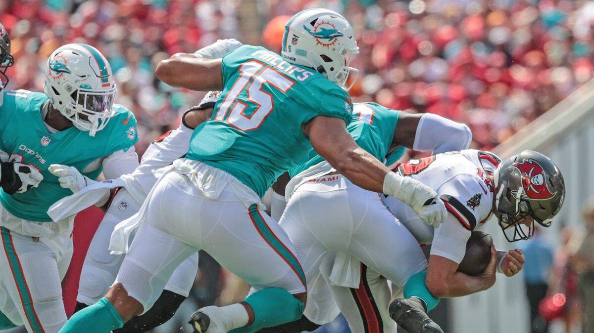 Miami Dolphins outside linebacker Jaelan Phillips (15) and =outside linebacker Jerome Baker (55) sack Tampa Bay Buccaneers quarterback Tom Brady (12) in the first half at Raymond James Stadium in Tampa on Sunday, October 10, 2021.