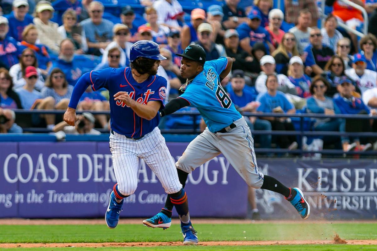 Miami Marlins Jose Devers (80) tags New York Mets center fielder Jake Marisnick (16) during the fourth inning of a spring training MLB game at Clover Park in Port St. Lucie, Florida on Saturday, February 22, 2020.