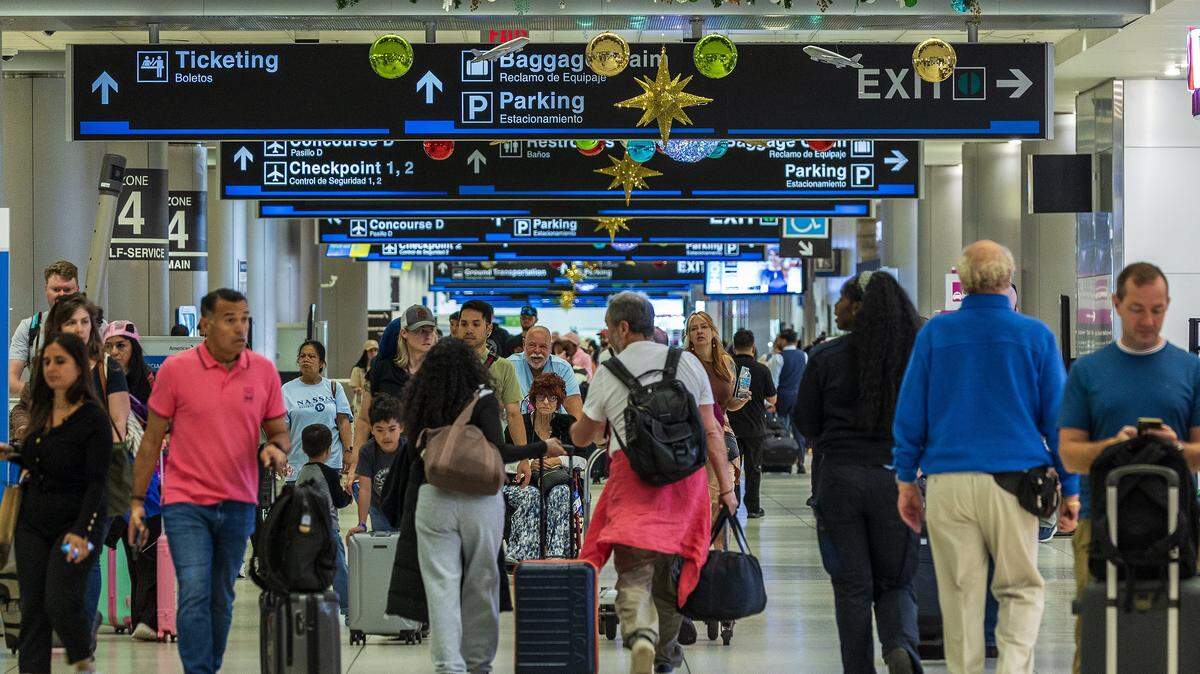 Passengers walked down the hallway in Concourse D, at Miami International Airport ahead of the Holidays in Miami, on Friday, November 21, 2025.