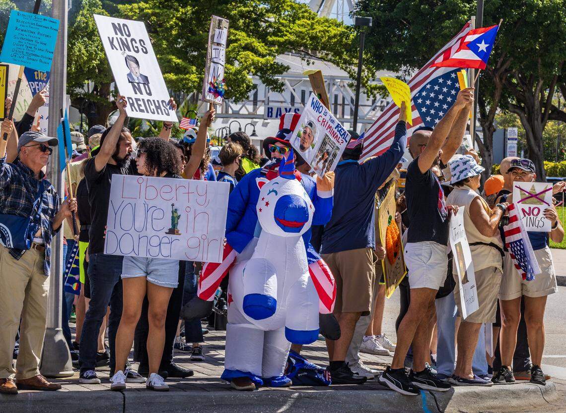 Protesters with signs at the Miami Torch of Friendship in downtown Miami during the ‘No Kings’ anti-Trump protests on Oct. 18, 2025.