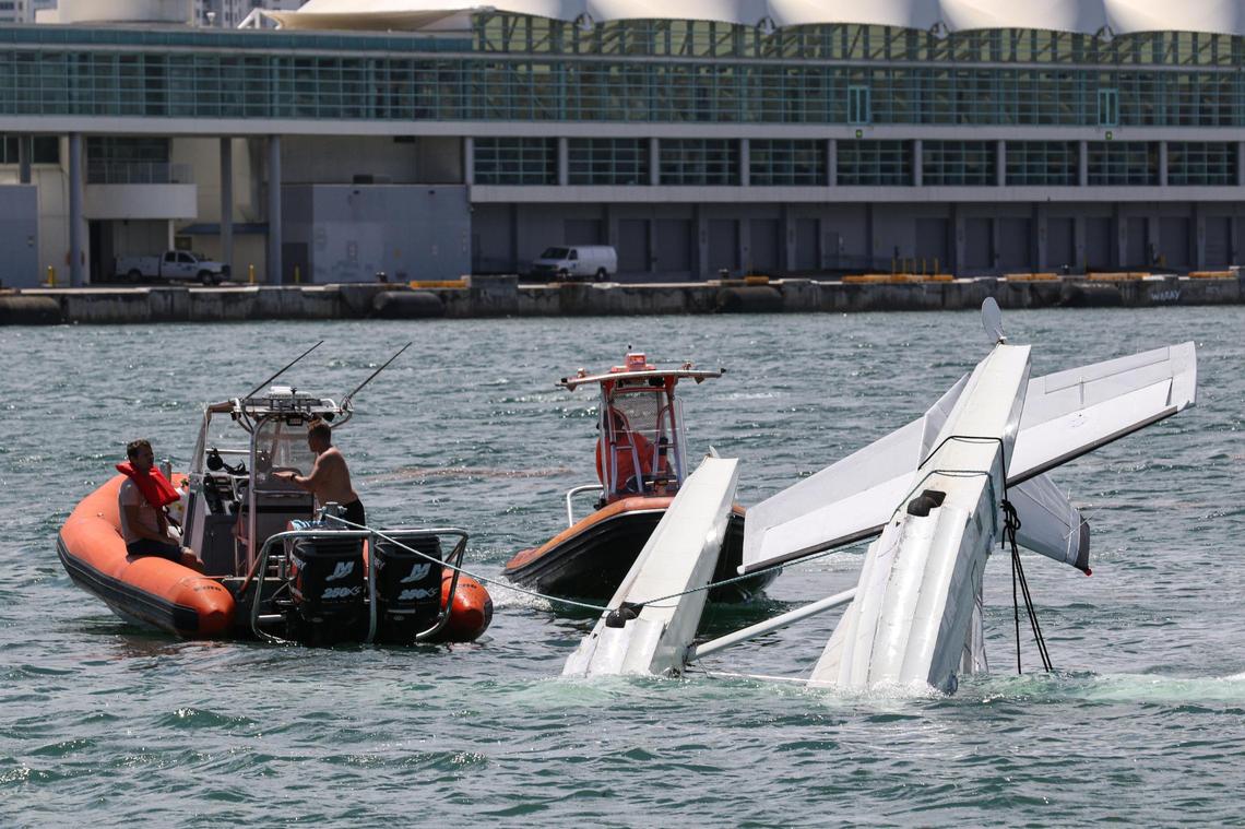 Sea towing boats respond to a seaplane overturned in the drink off the Port of Miami, Saturday, August 22, 2020.