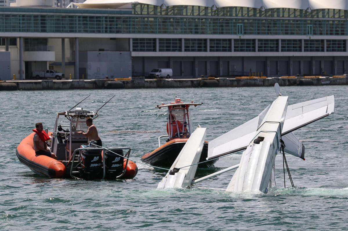 Sea towing boats respond to a seaplane overturned in the drink off the Port of Miami, Saturday, August 22, 2020.