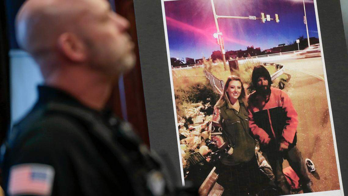 A law enforcement official stands next to a picture of Katelyn McClure and Johnny Bobbitt Jr., on display during a news conference in Mt. Holly, N.J., Thursday, Nov. 15, 2018.