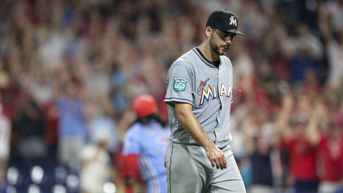 Miami Marlins relief pitcher Kyle Barraclough walks off the field after Philadelphia Phillies’ Maikel Franco, rear, hit a walk-off three-run home run in a baseball game Thursday, Aug. 2, 2018, in Philadelphia. The Phillies won 5-2. (AP Photo/Laurence Kesterson)