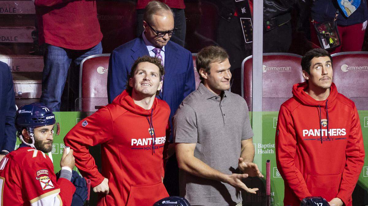 Florida Panthers winger Matthew Tkachuk (left) and center Aleksander Barkov (center) watch as the 2025 Stanley Cup banner is raised into the rafters before their NHL home opener against the Chicago Blackhawks at the Amerant Bank Arena on Oct. 7, 2025 in Sunrise, Fla.