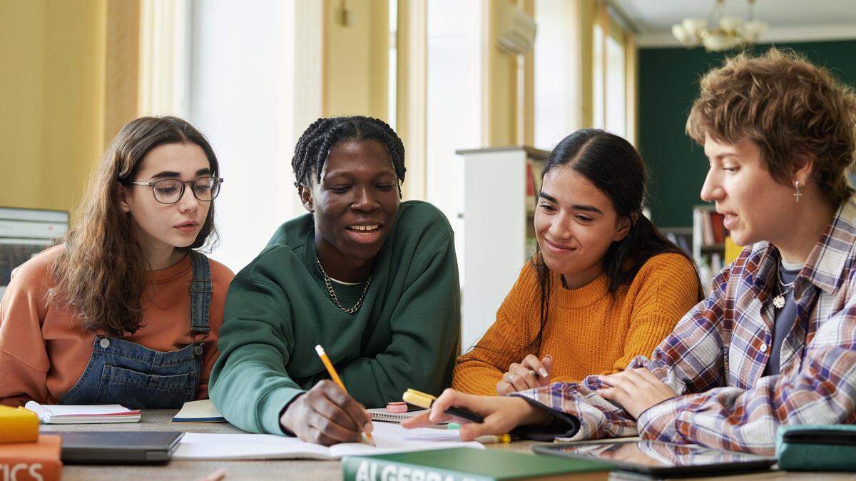 A roup of students works on an algebra project in a classroom.