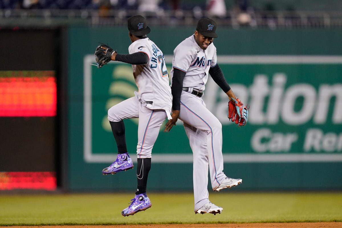 Miami Marlins second baseman Jazz Chisholm Jr., left, and Miami Marlins right fielder Jesus Sanchez celebrate after winning a baseball game against the Washington Nationals, Tuesday, April 26, 2022, in Washington. Miami won 5-2. (AP Photo/Patrick Semansky)