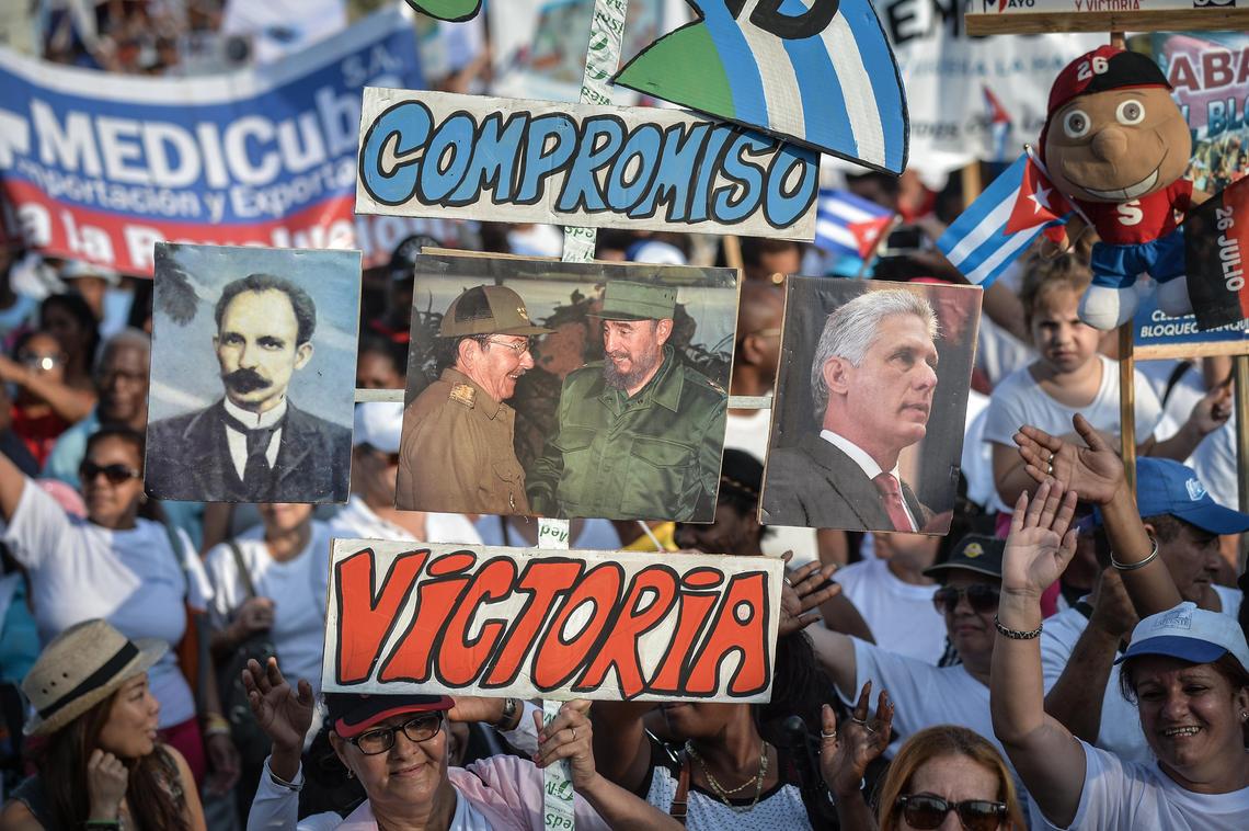 People display posters of, from left, Cuban national hero Jose Martí, former presidents Raúl and Fidel Castro and current President Miguel Díaz-Canel during the May Day rally at Revolution Square in Havana on May 1, 2018.