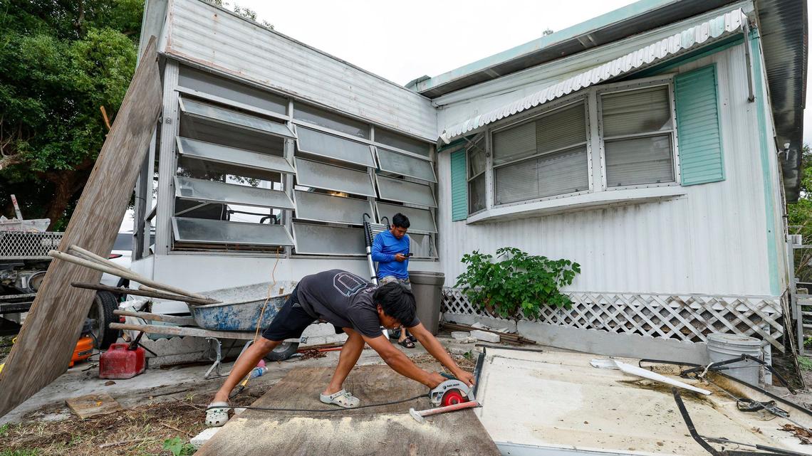 As Hurricane Milton approaches, Juan Alonso, 19, and Andres Alonso, 29, prepare to board up their family home already damaged by Hurricane Helene at Fairmont Mobile Home Estates in Ruskin, Florida on Tuesday, October 8, 2024.