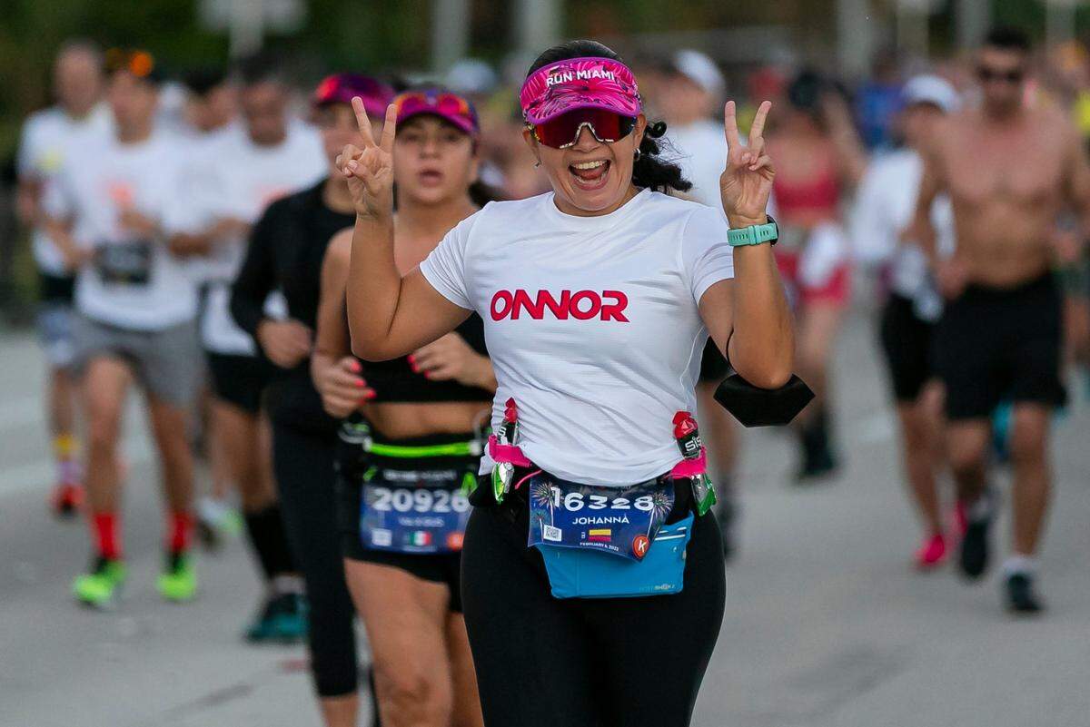 Una corredora saluda mientras participa en la vigésima edición del Life Time Maratón de Miami, el domingo 6 de febrero de 2022.