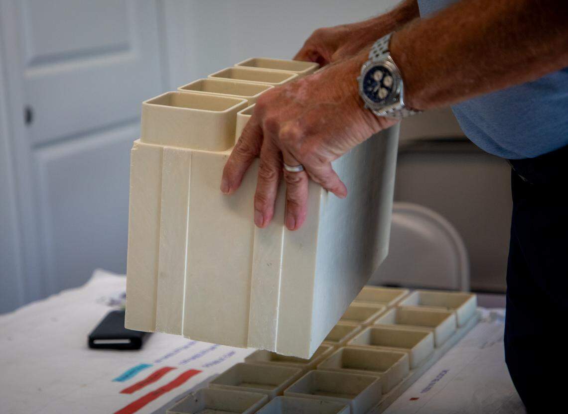 Kenneth Smuts shows how the blocks made from recycled plastic, glass and stone stack.