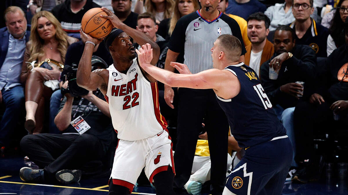 Miami Heat forward Jimmy Butler (22) shoots against Denver Nuggets center Nikola Jokic (15) in the second quarter in Game Two of the 2023 NBA Finals at Ball Arena.