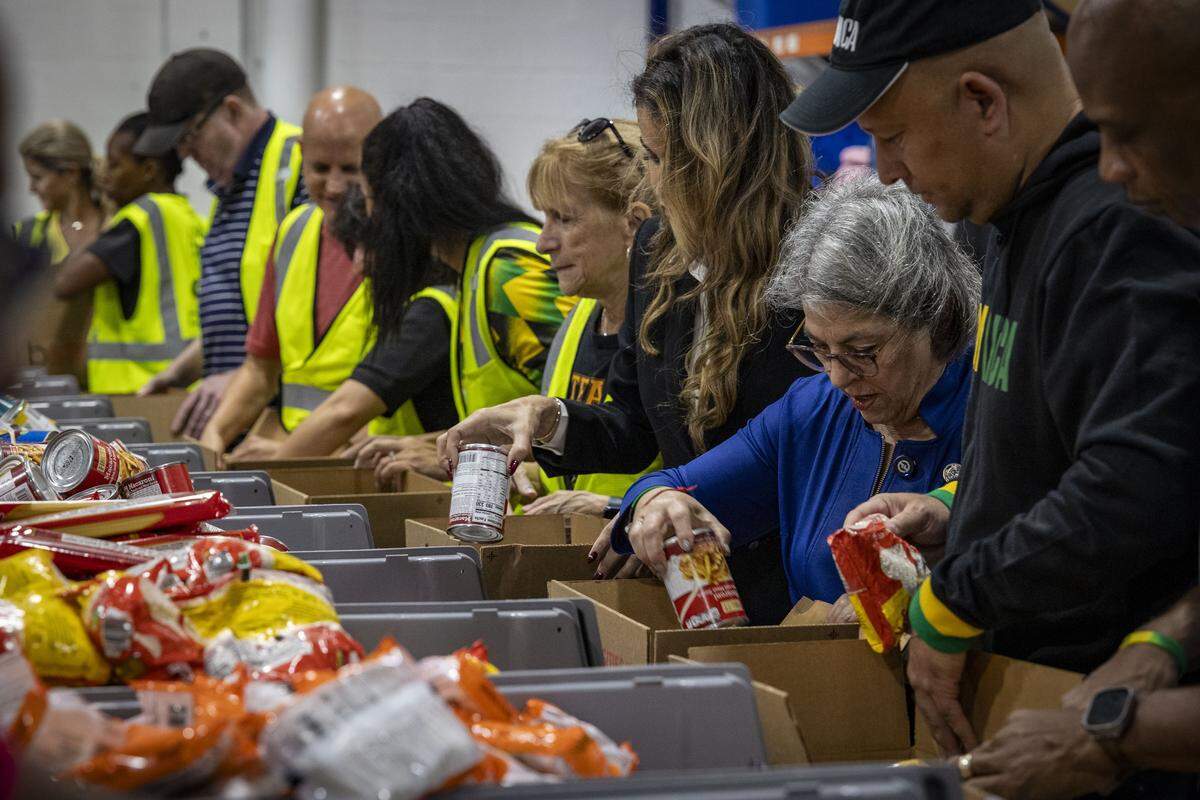 Oliver Mair, el cónsul general de Jamaica, la alcaldesa del condado de Miami-Dade, Daniella Levine Cava, y la comisionada Danielle Cohen Higgins empacan cajas de ayuda destinadas a Jamaica después del paso del huracán Melissa en Global Empowerment Mission en Doral.