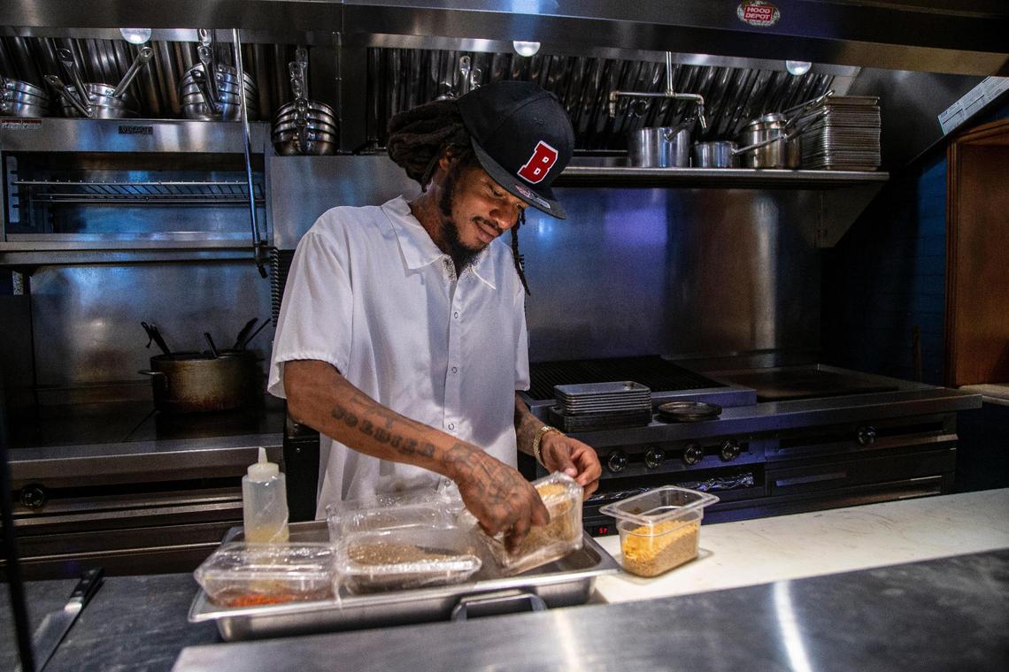 Brian Aikens, an Overtown resident, gets ready for his shift as a line cook at the Red Rooster restaurant in the heart of the resurgent historic Miami neighborhood in May.
