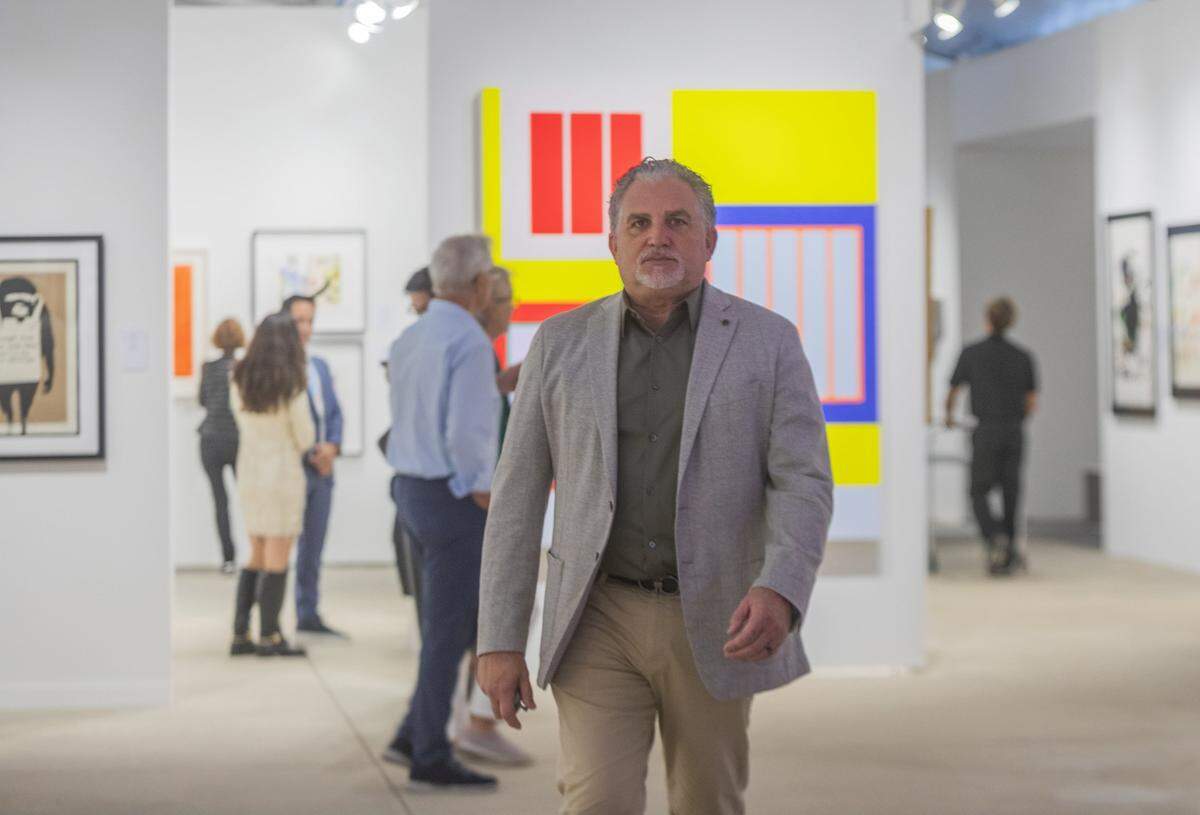 Nick Korniloff Director Art Miami walks infront of Breakthrough a PETER HALLEY painting (b. 1953)2019; Acrylic, Fluorescent Acrylic, and Roll-a-Tex on Canvas at ART MIAMI in MIami on Tuesday December 2nd., 2025.