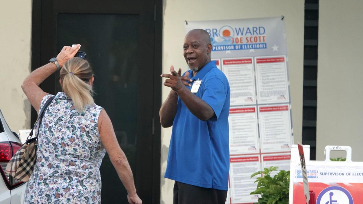 Un trabajador electoral saluda a una votante el martes 23 de agosto de 2022 en el salón de los estibadores, en Fort Lauderdale, durante el día de las elecciones primarias del Condado Broward. En la Junta Escolar del Condado Broward, 22 candidatos se presentaron entre seis carreras. Tres titulares estaban en la boleta.