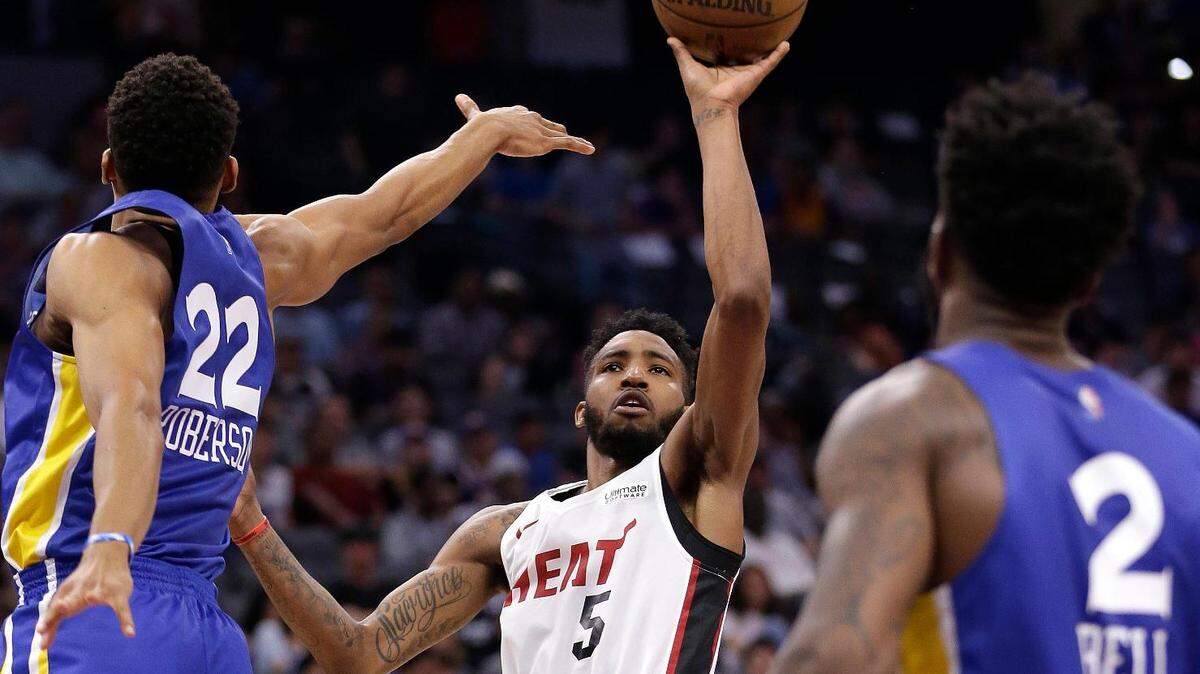 Miami Heat guard Derrick Jones Jr. goes to the basket between Golden State Warriors forward Jeff Roberson, left, and Jordan Bell  during the first half of an NBA summer league game on Monday in Sacramento.