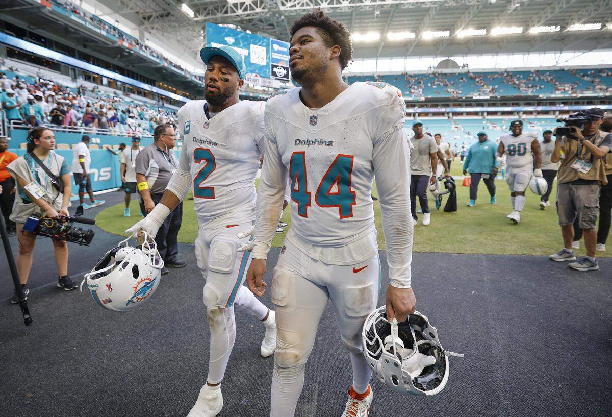 Miami Dolphins linebacker Bradley Chubb (2) and linebacker Chop Robinson (44) walk off the field after the New England Patriots defeat the Dolphins during an NFL football game at Hard Rock Stadium in Miami Gardens, Florida, on Sunday, September 14, 2025. 