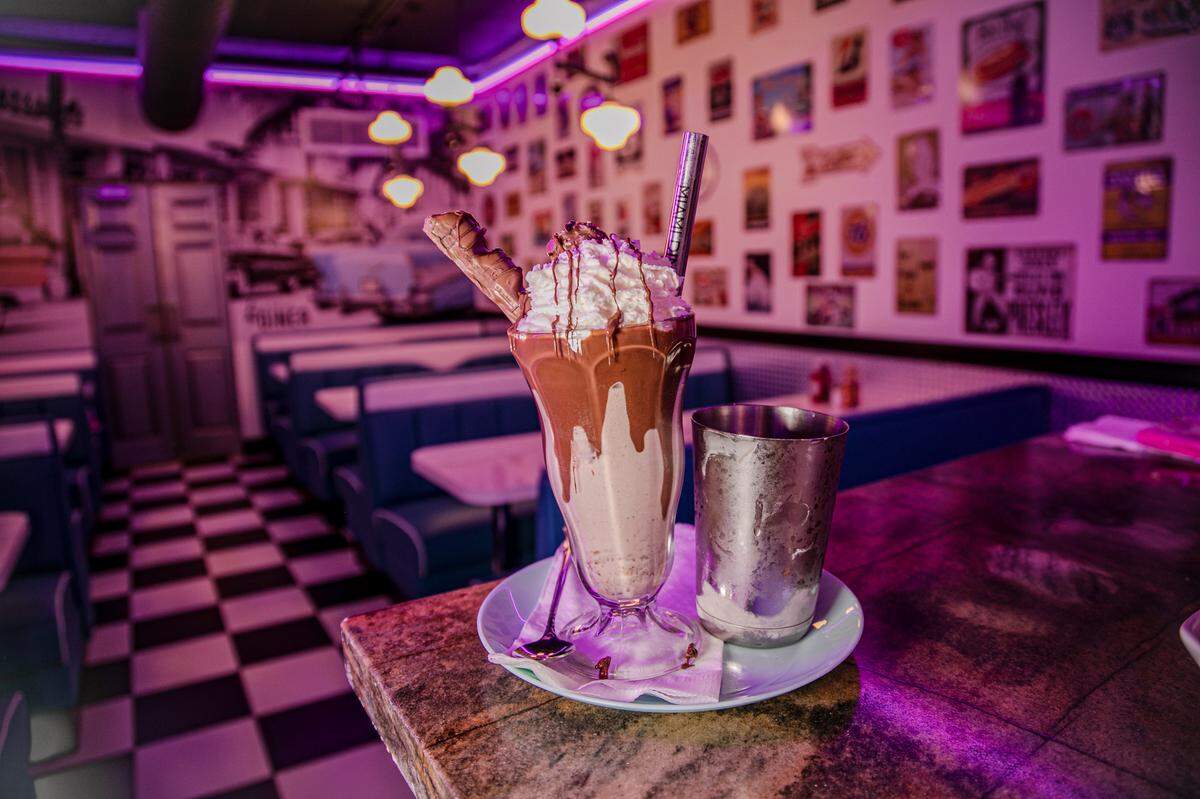 The Nutella Ferrero Milkshake is vanilla ice cream topped with whipped cream, Ferrero Rocher chocolate and a Kinder Bueno Chocolate Bar.