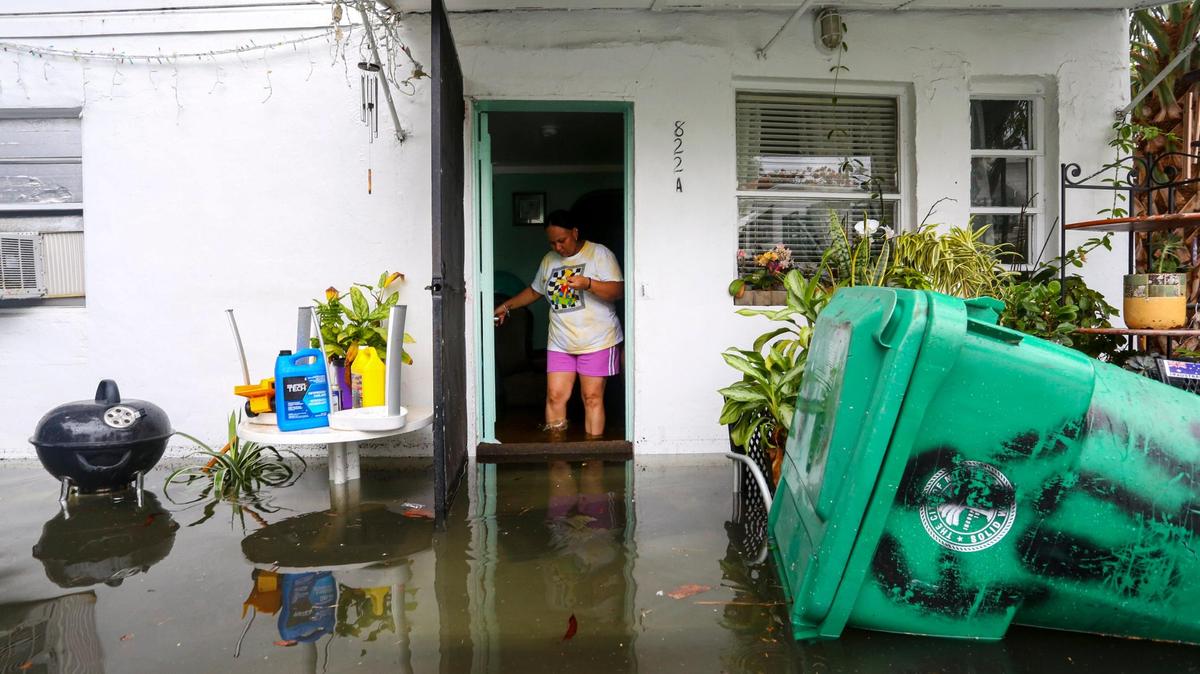 Magda Murillo, que vive en SW Third Street, sale de su casa inundada en La Pequeña Habana en Miami, Florida, el sábado 4 de junio de 2022.