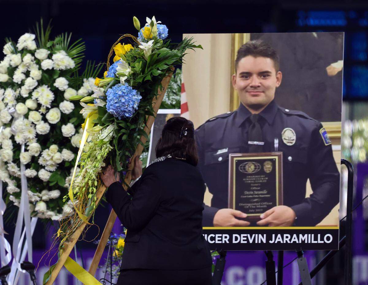 Wreath of flowers are place next to the photo of Jaramillo in preparation of the funeral service for Miami-Dade Deputy Sheriff Devin Jaramillo at Loan Deport Park, where multi-agency officers, public servants, friends, and family members gathered to honor the fallen deputy on Tuesday, November 18, 2025, in Miami, Florida.