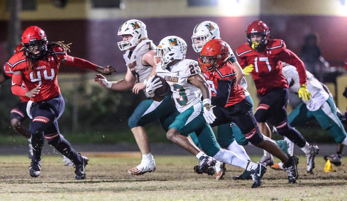 Mandarin Mustangs Deshard Westcott, running back (23), carries the ball against the Monarch Knights, during the state semifinal football, at Coconut Creek High School, on Friday December 01, 2023.