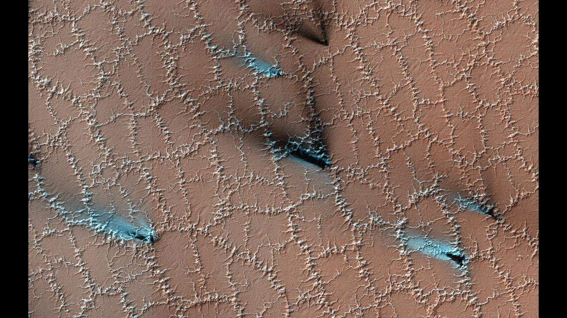 This image shows evidence geysers releasing material on the surface of Mars, NASA says. “Translucent carbon dioxide ice allows sunlight to shine through and heat gases that escape through vents, releasing fans of darker material onto the surface,” scientists say.