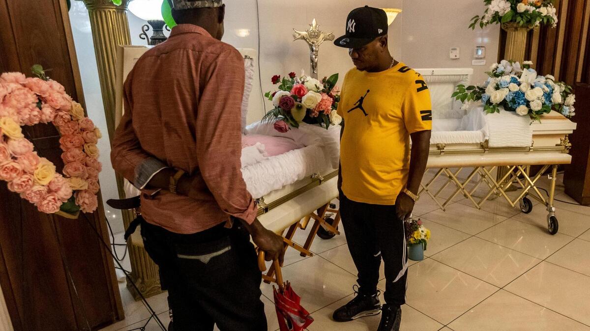 Frantzy Belval, center, father of Laura and Jeffry Belval, approaches the caskets at the viewing for the two children at Emmanuel Funeral Home in North Miami Beach on June 3, 2022. According to police, the 5-year-old girl and 3-year-old boy were strangled by their mother on April 12.