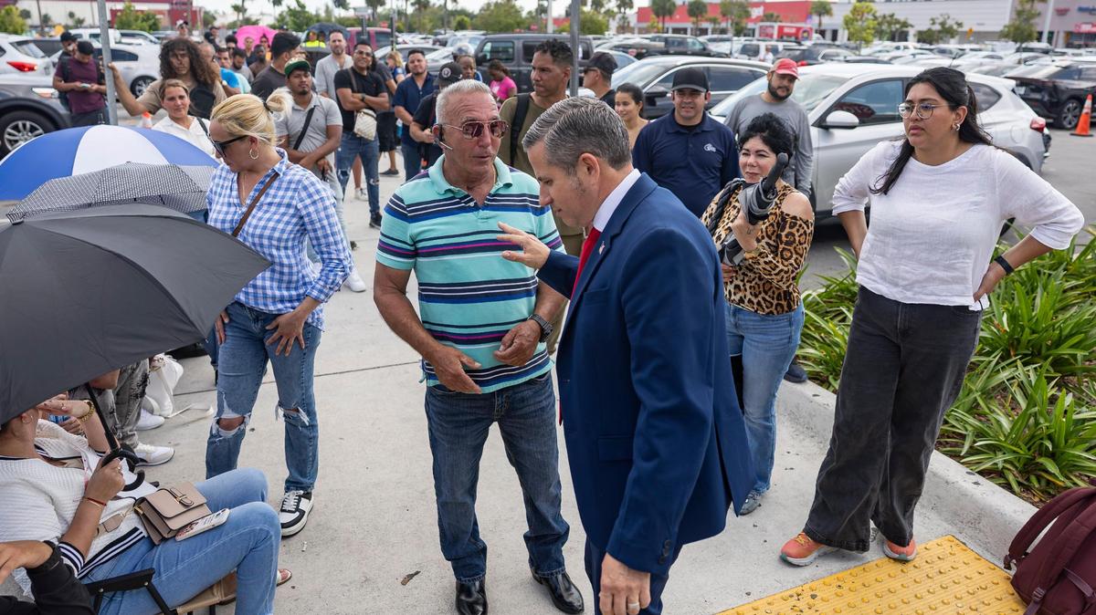 El recaudador de Impuestos de Miami-Dade, Dariel Fernández, habla con un residente de Miami Gardens, fuera de una oficina de licencias de conducir del DMV el 16 de abril de 2025.