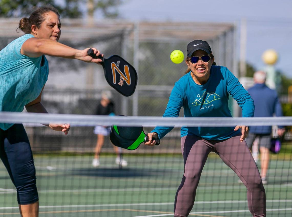 Fabiola Perez, 49, left, and Maria Elena Guinand, 57, play a game of pickleball at Suniland Park in Pinecrest, Florida on Friday, January 14, 2022.