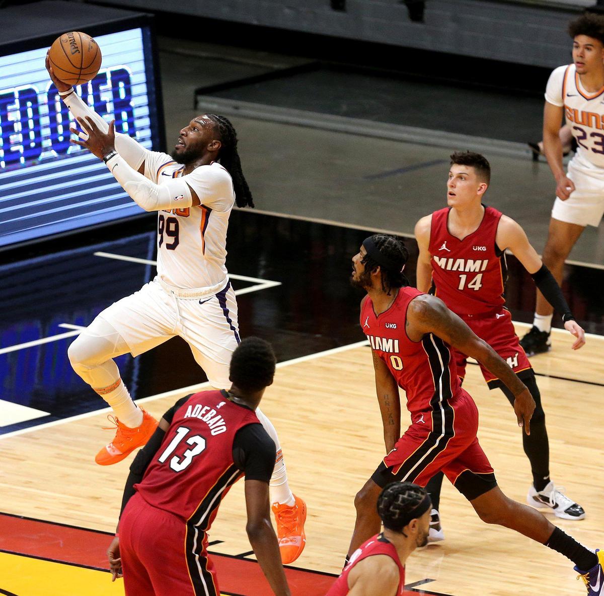 Miami Heat players watch Phoenix Sun Jae Crowder (99) leap for a basket in the first quarter at the AmericanAirlines Arena in Miami, Florida, Tuesday, March 23, 2021. Crowder was a Heat player last season as they played for the NBA Championship but lost to the LA Lakers.