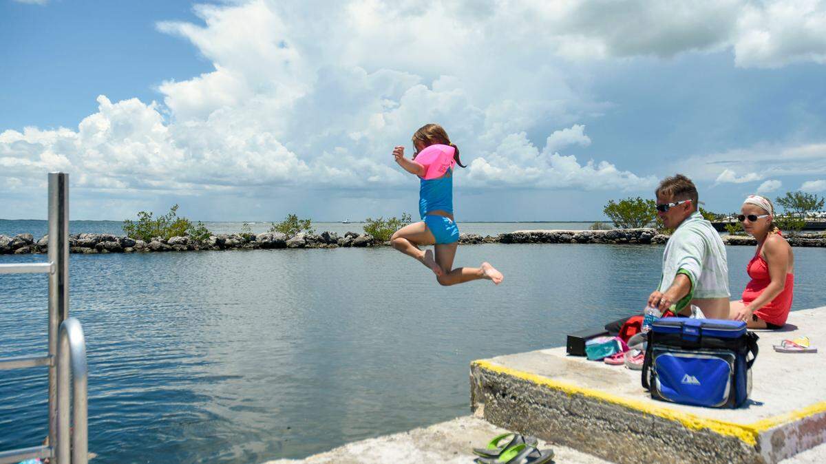 A girl jumps from the seawall of a swimming area at Rowell's Waterfront Park in Key Largo in 2016.