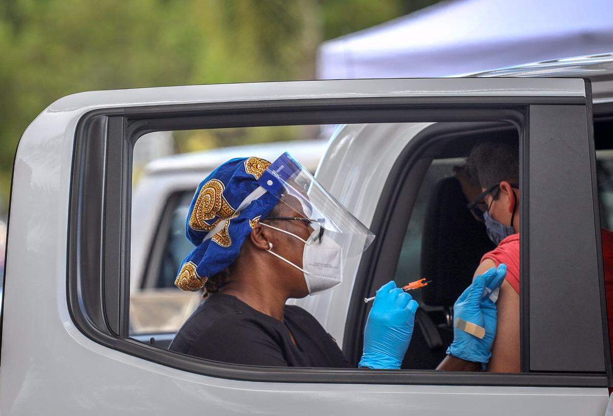 Cars line up as healthcare workers administer COVID-19 Pfizer vaccinations at Dolphin Mall on Tuesday, May 11, 2021.