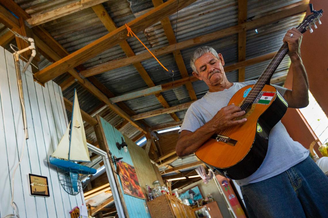 Guillermo Jose Torres, 60, plays his guitar in his hurricane damaged beachfront house in the Playita Cortada community in Santa Isabel, Puerto Rico. Torres patched the roof that Maria ripped off but it continues to leak. He complains the $500 he received in federal aid was not enough to complete repairs.