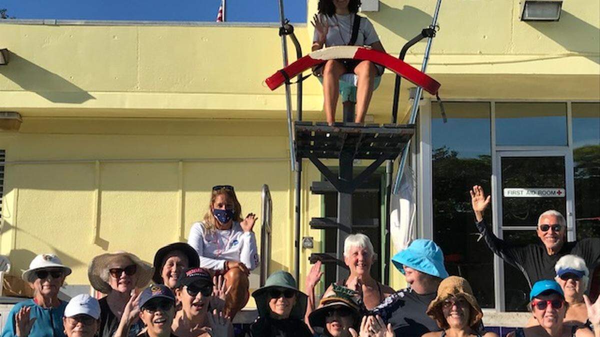 Russlyn LaCanne with recent members of her water-exercise class. LaCanne is beneath the lifeguard stand, in front — low in the water.