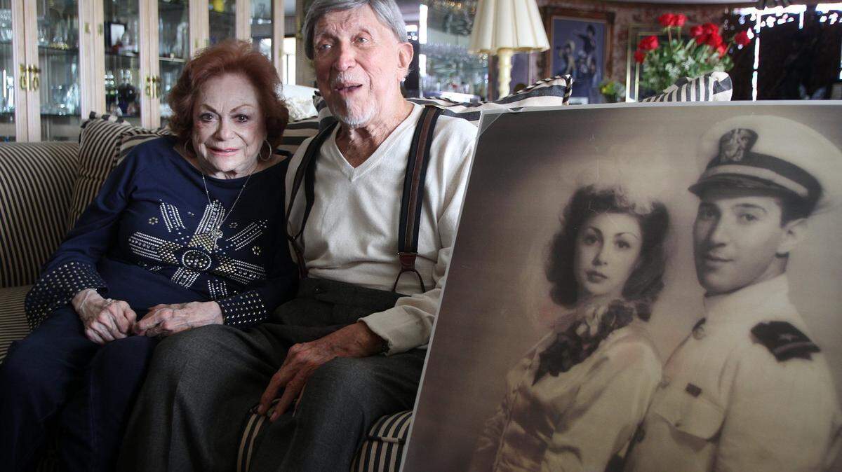 On April 9, 2013, Selma and Ben Grenald pose together in their Miami Shores apartment next to their wedding photo taken in June 1943. Grenald was serving in the Navy in May 1943 when he helped with the capturing of eight German prisoners of war who had escaped from the Queen Mary ship, docked next to his post.