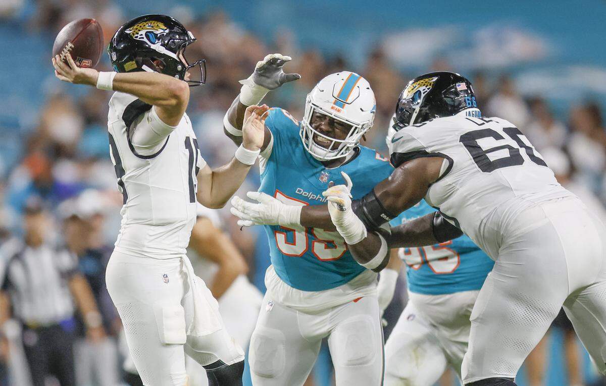 Miami Dolphins linebacker Derrick McLendon (59) rushes Jacksonville Jaguars quarterback Seth Henigan (19) in the second half of an NFL football game at Hard Rock Stadium in Miami Gardens, Florida, on Saturday, August 23, 2025.