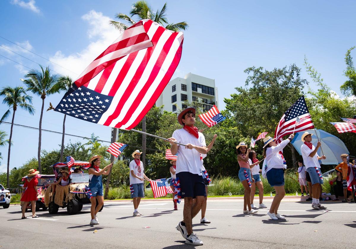 A parade participant waves the American flag at an Independence Day celebration on Thursday, July 4, 2024 in Key Biscayne, Fla. The Key Biscayne July Fourth parade is one of the oldest parades in South Florida, starting in 1959 and celebrating its 65th year.