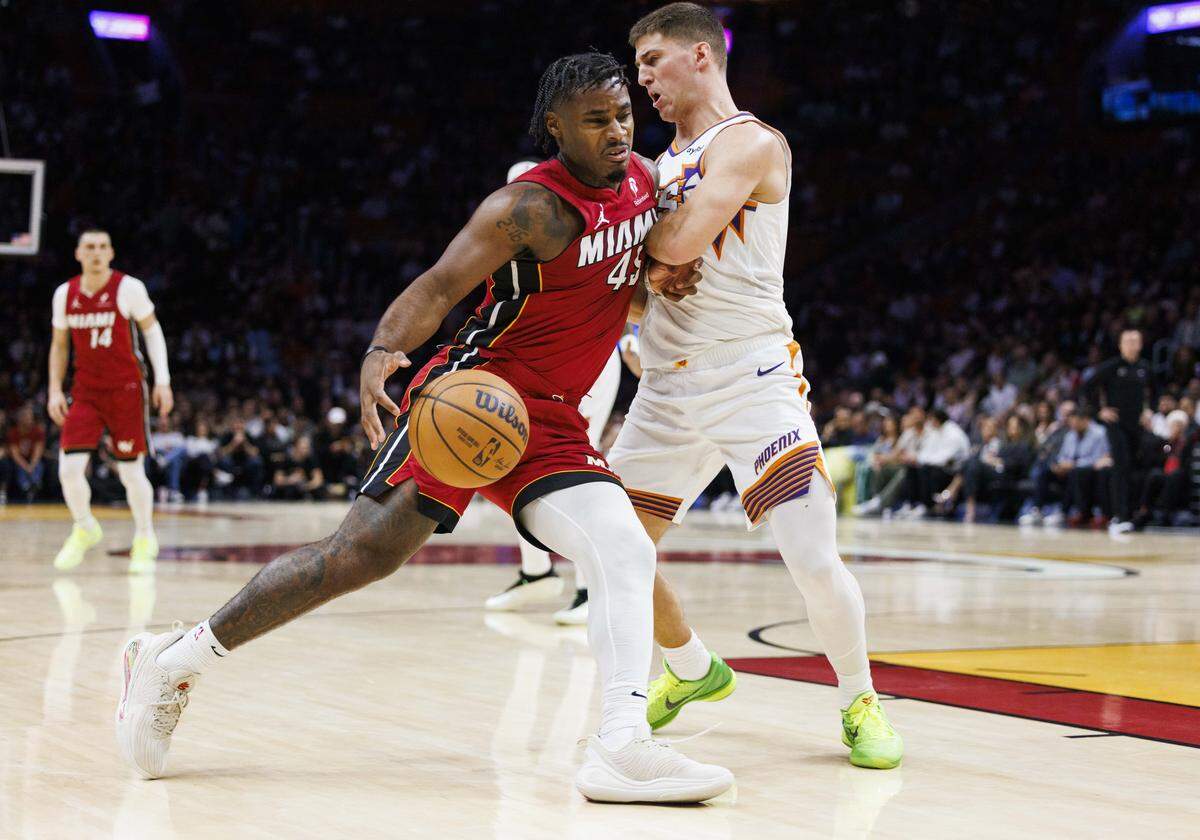 Miami Heat guard Davion Mitchell (45) drives passed Phoenix Suns guard Collin Gillespie (12) during the first half of a game on Tuesday, Jan. 13, 2026, at the Kaseya Center in downtown Miami, Fla. 