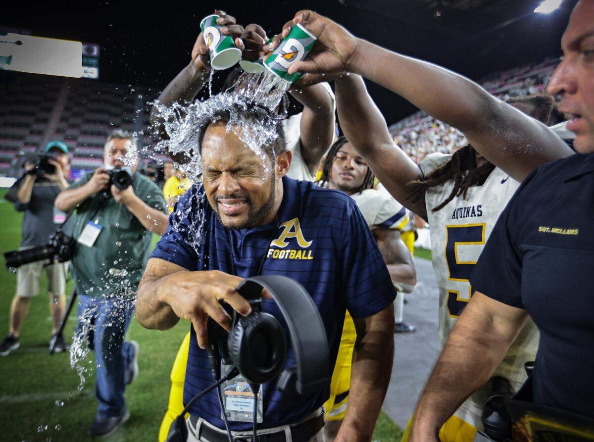 St. Thomas Aquinas coach Roger Harriott gets doused with water as the Raiders celebrate defeating Tampa Bay Tech in the FHSAA Class 7A State Championship at DRV PNK Stadium, in Fort Lauderdale on Friday, December 17, 2021.