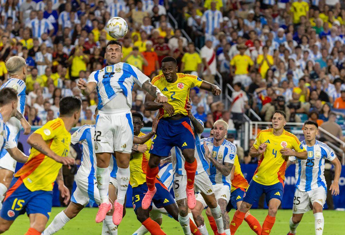 Argentina forward Lautaro Martínez (22) heads the ball in front of Colombia defender Carlos Cuesta (2) in extra time of the Copa America 2024 Final soccer match at Hard Rock Stadium on Sunday, July 14, 2024, in Miami Gardens, Fla.
