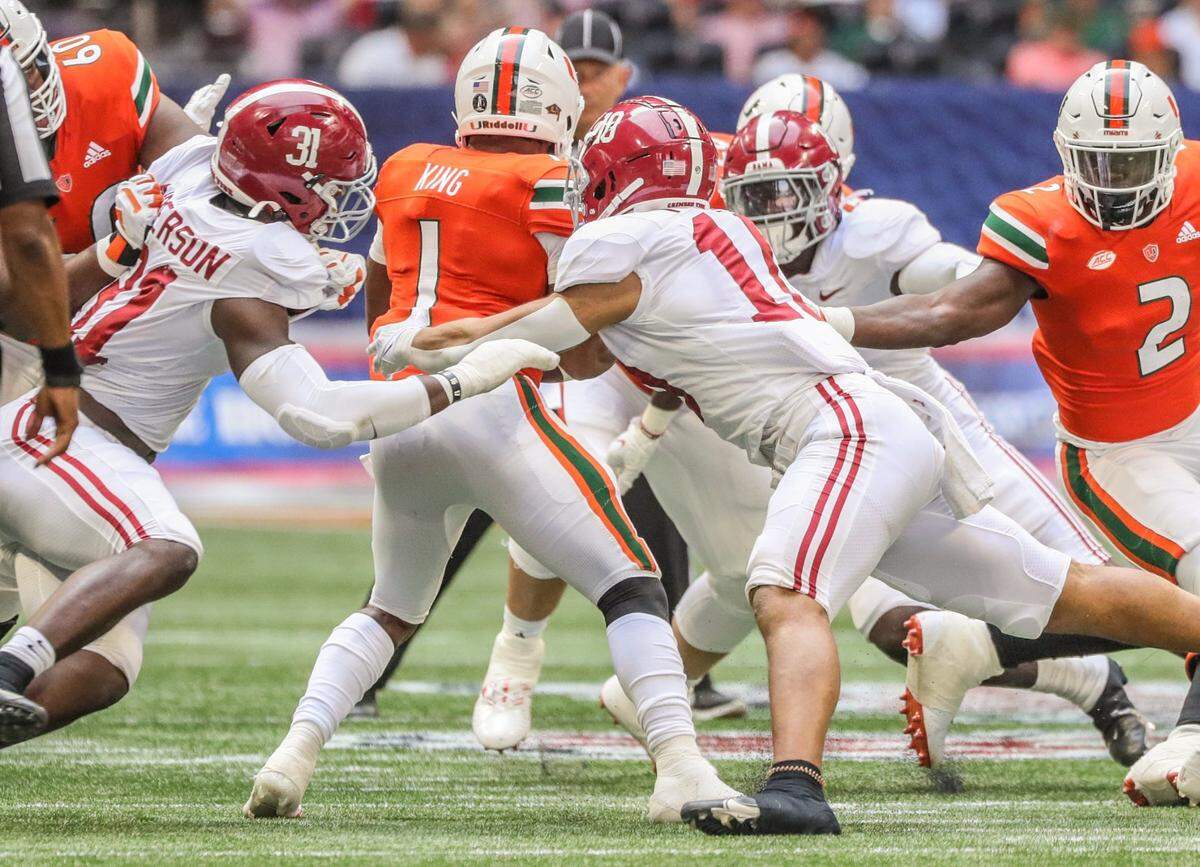 Miami Hurricanes quarterback D’Eriq King (1) is pressured by Alabama Crimson Tide defenders in the second quarter at Mercedes Benz Stadium in Atlanta on Saturday, September 4, 2021.