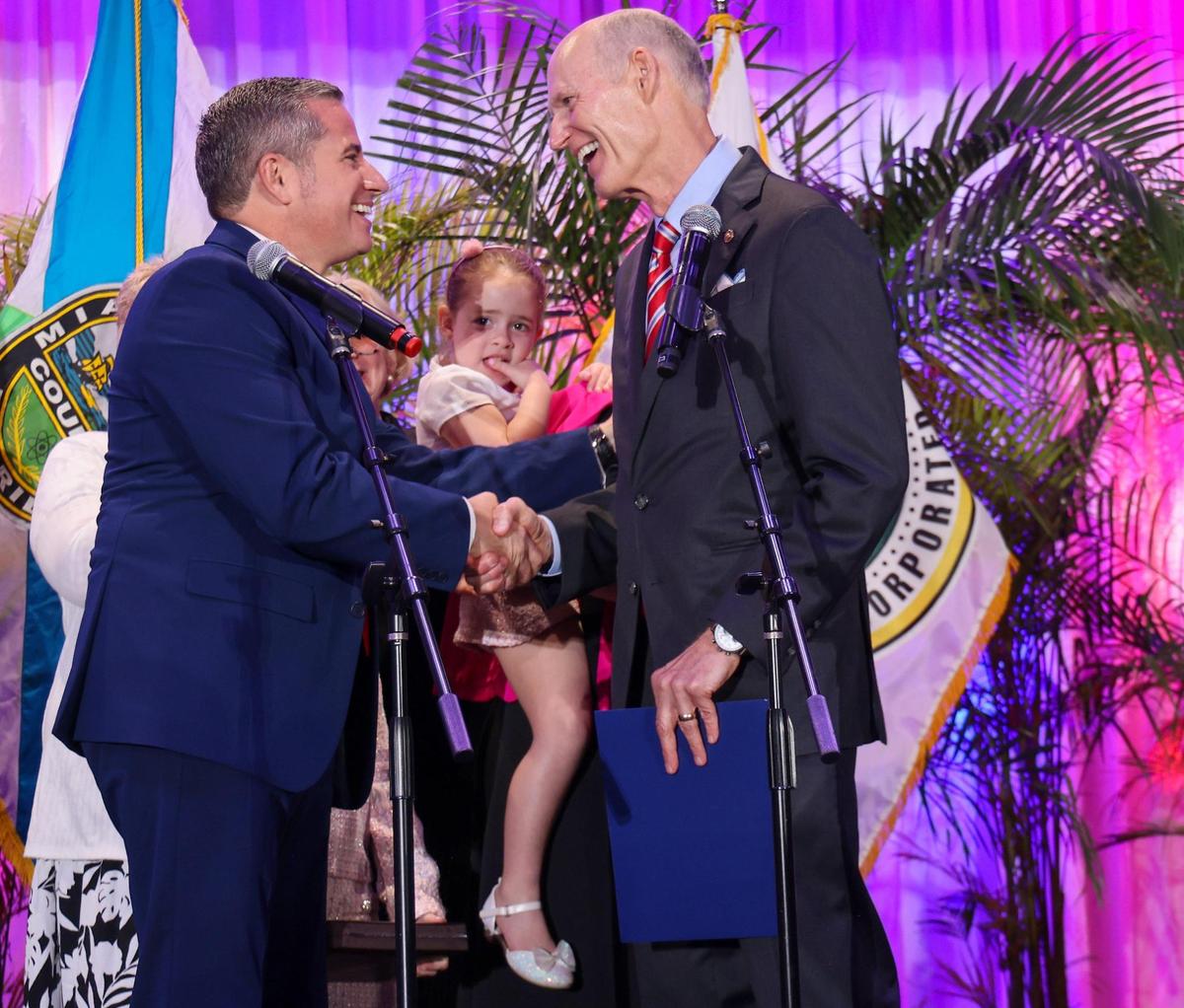 Tax Collector Daniel Fernandez, left, shakes the hands of U.S. Sen. Rick Scott, right, as Fernandez’s daughter Anastasia, center, looks on after he took the oath of office during the installation ceremony for supervisor of elections, tax collector and property appraiser and were all sworn in by Sen. Rick Scott at the Milander Auditorium in Hialeah, Florida, on Monday, Jan. 13, 2025.
