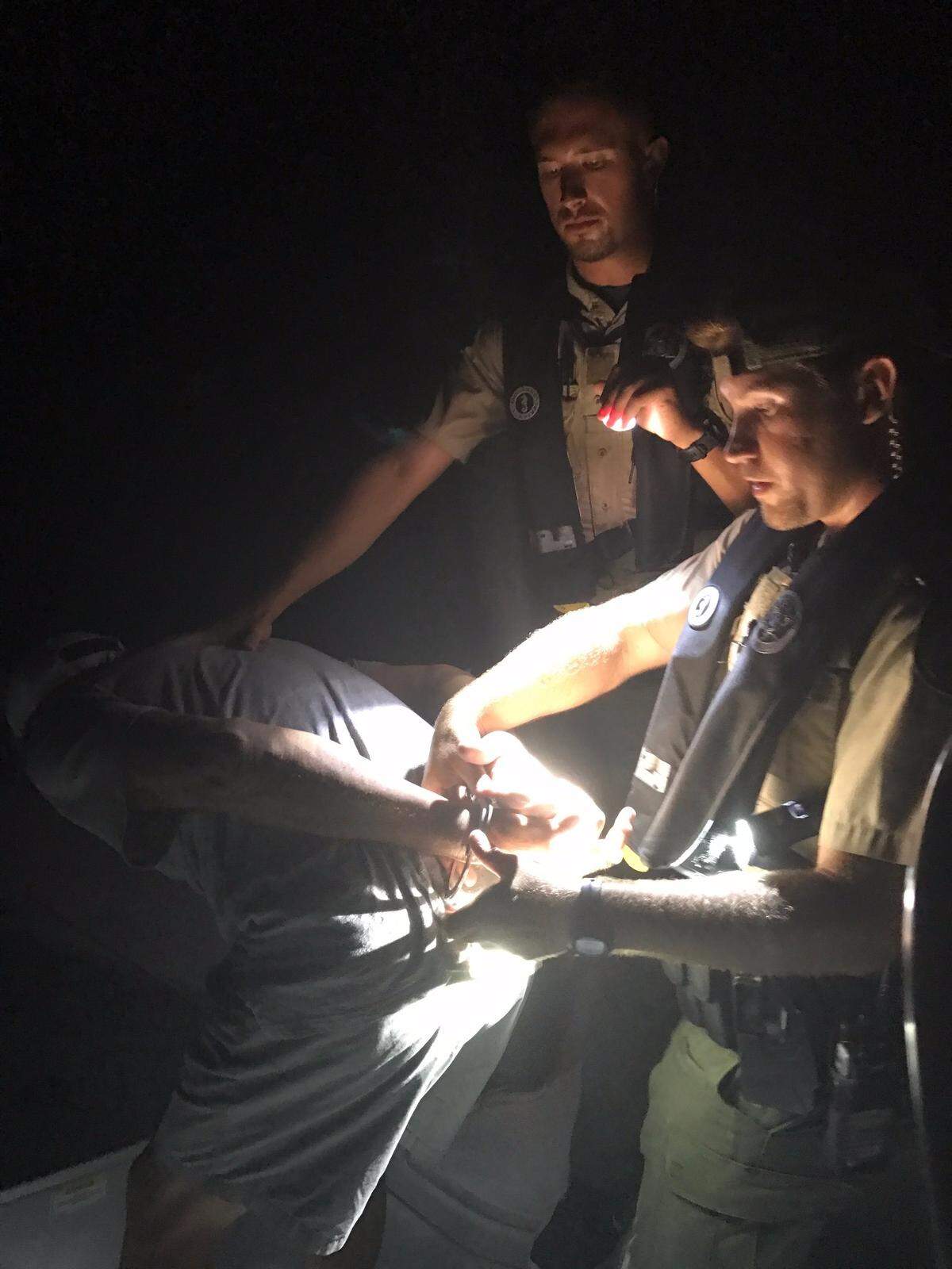 Florida Fish and Wildlife Conservation Commission Officers Billy Thompson and Zach Hoppe cuff a man who they said failed a series of field sobriety tests Tuesday, July 24, 2018.