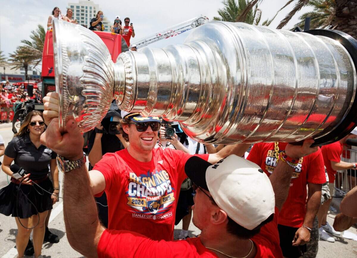 Florida Panthers center Carter Verhaeghe (23) hands the cup to center Brad Marchand (63) before the Florida Panthers Stanley Cup Championship victory parade on Sunday, June 22, 2025 down Las Olas in Fort Lauderdale, Fla.