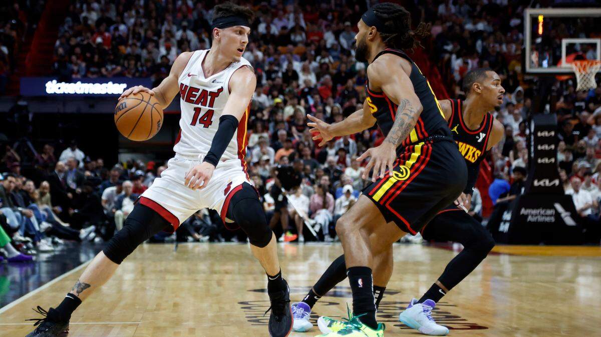 El escolta del Heat Tyler Herro (izq.) conduce el balón ante la marca de Patty Mills, de los Hawks de Atlanta, en el partido celebrado el 22 de diciembre de 2023 en Miami.