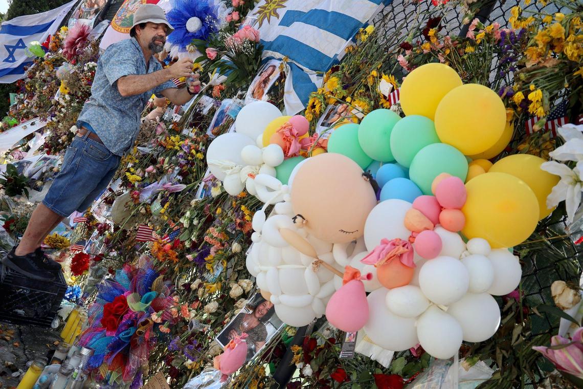 On Wednesday, July 14, 2021, twenty-one days after the partial collapse of the Champlain Tower South, the recovery efforts continue. Bernardo Camou add personal items on the fence of the memorial site in memory of his sister Maria Gabriela Camou, a victim of the collapse whose body was located last Thursday. Bernardo Camou and his sister traveled from Uruguay to visit the site.