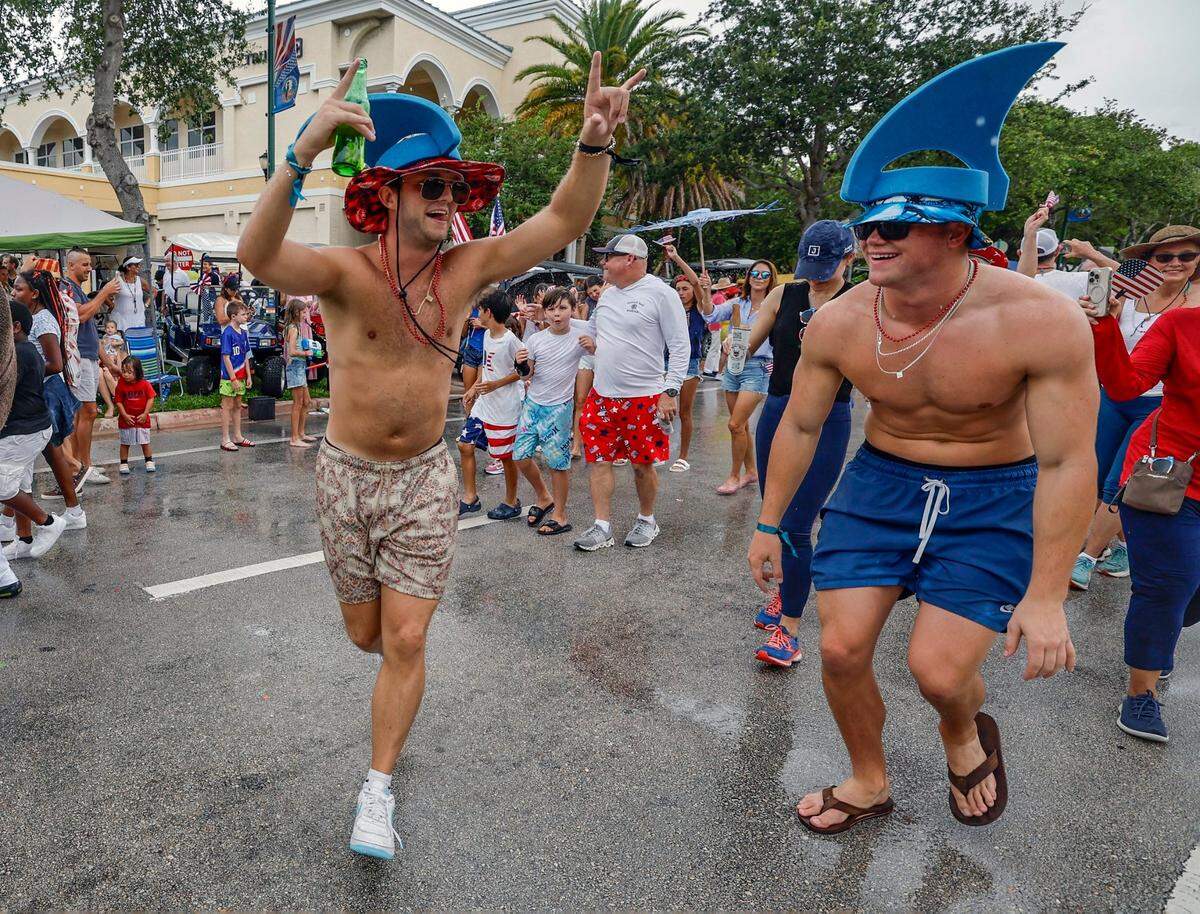Mitchell Bigelow, and Josh Hall, left to right, dance as along Crandon Boulevard as they celebrate Independence Day during the 66th Annual Key Biscayne Fourth of July Parade on Key Biscayne, Florida on Friday, July 4, 2025.