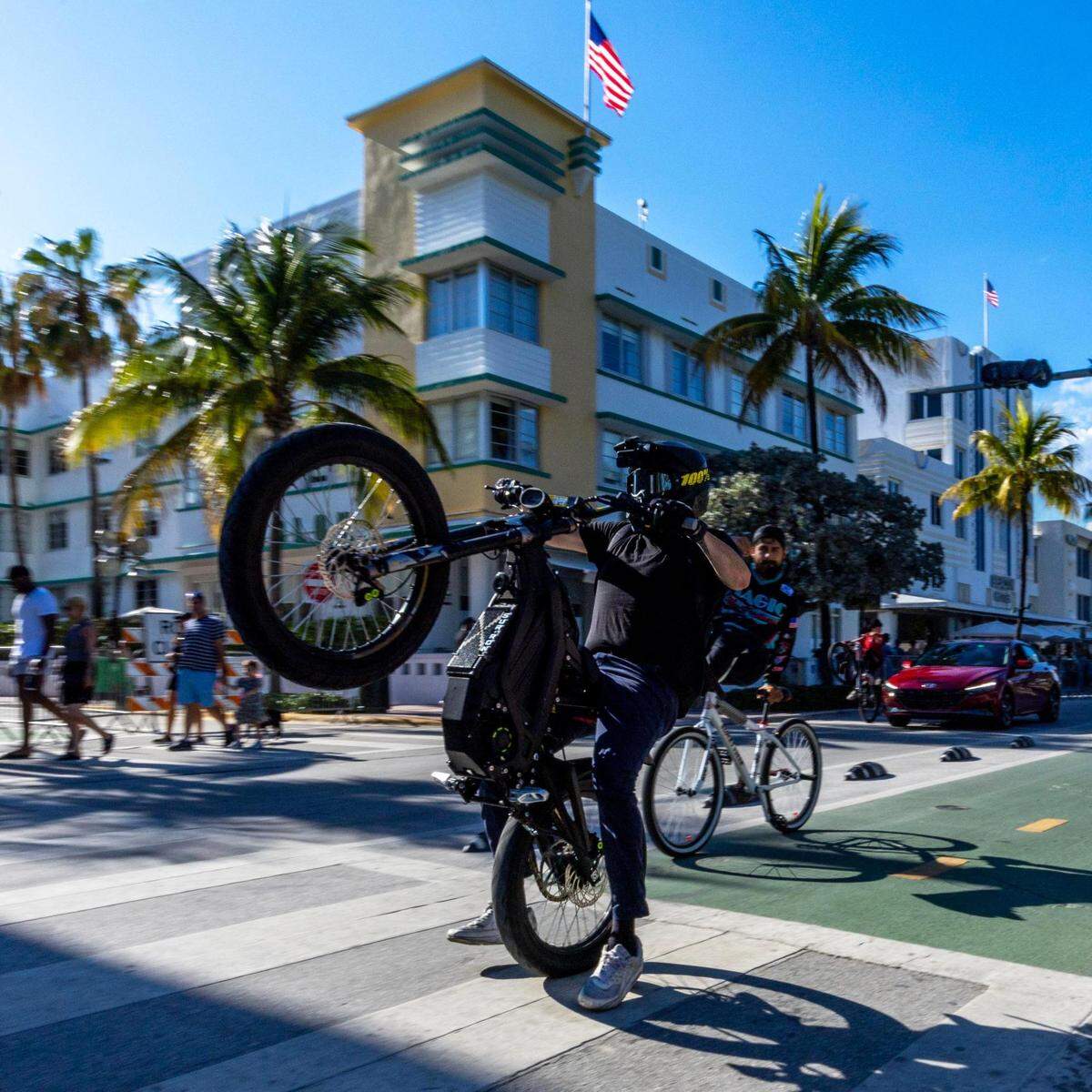 A bicyclist pops a wheelie on Ocean Drive during Memorial Day weekend at Miami Beach, Florida, on Sunday, May 28, 2023.
